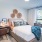 Bedroom  with bed next to window and sleek plank flooring The Beam New London CT luxury apartments